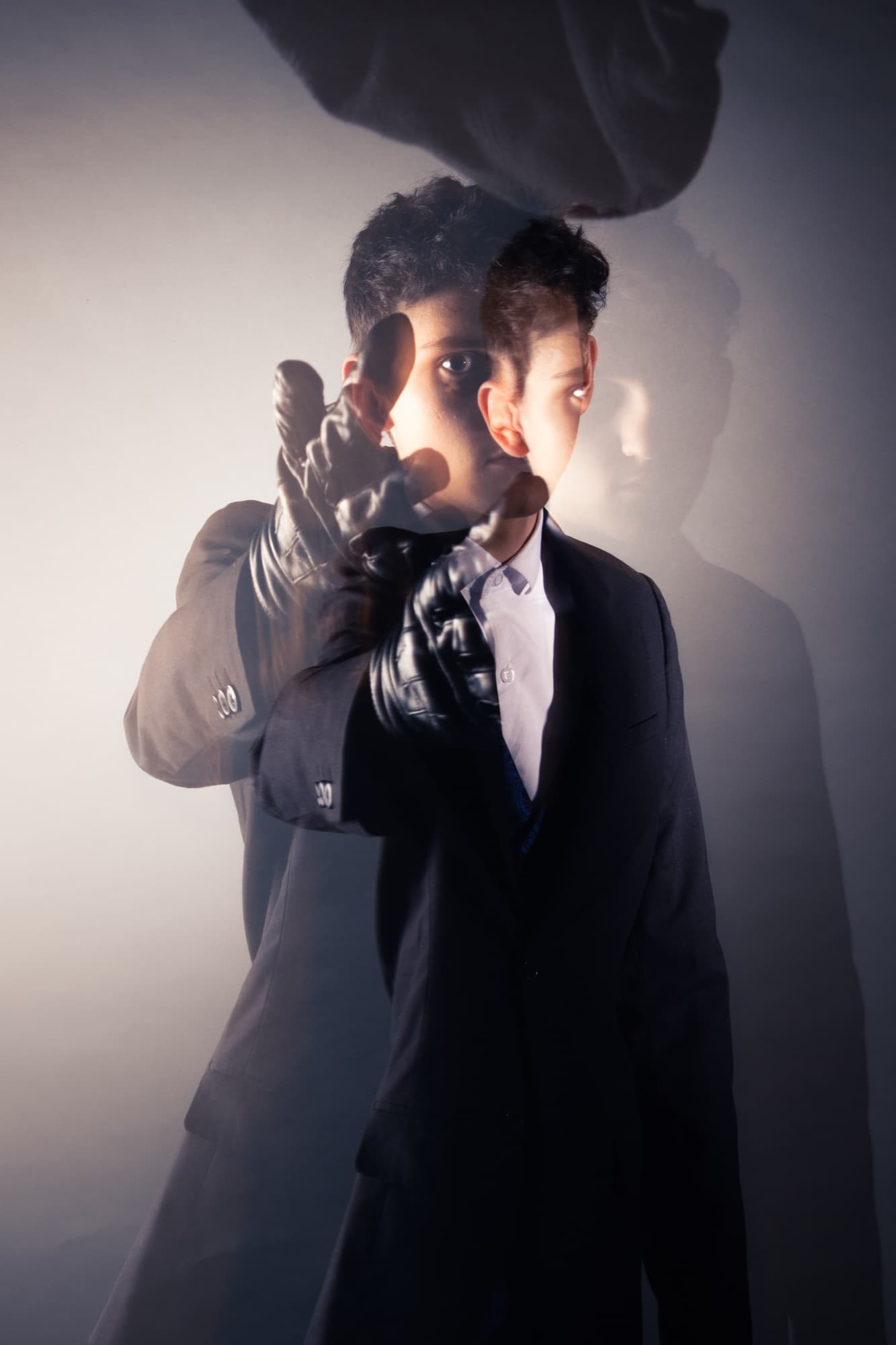 Portrait en double exposition, costume sombre et gants de cuir