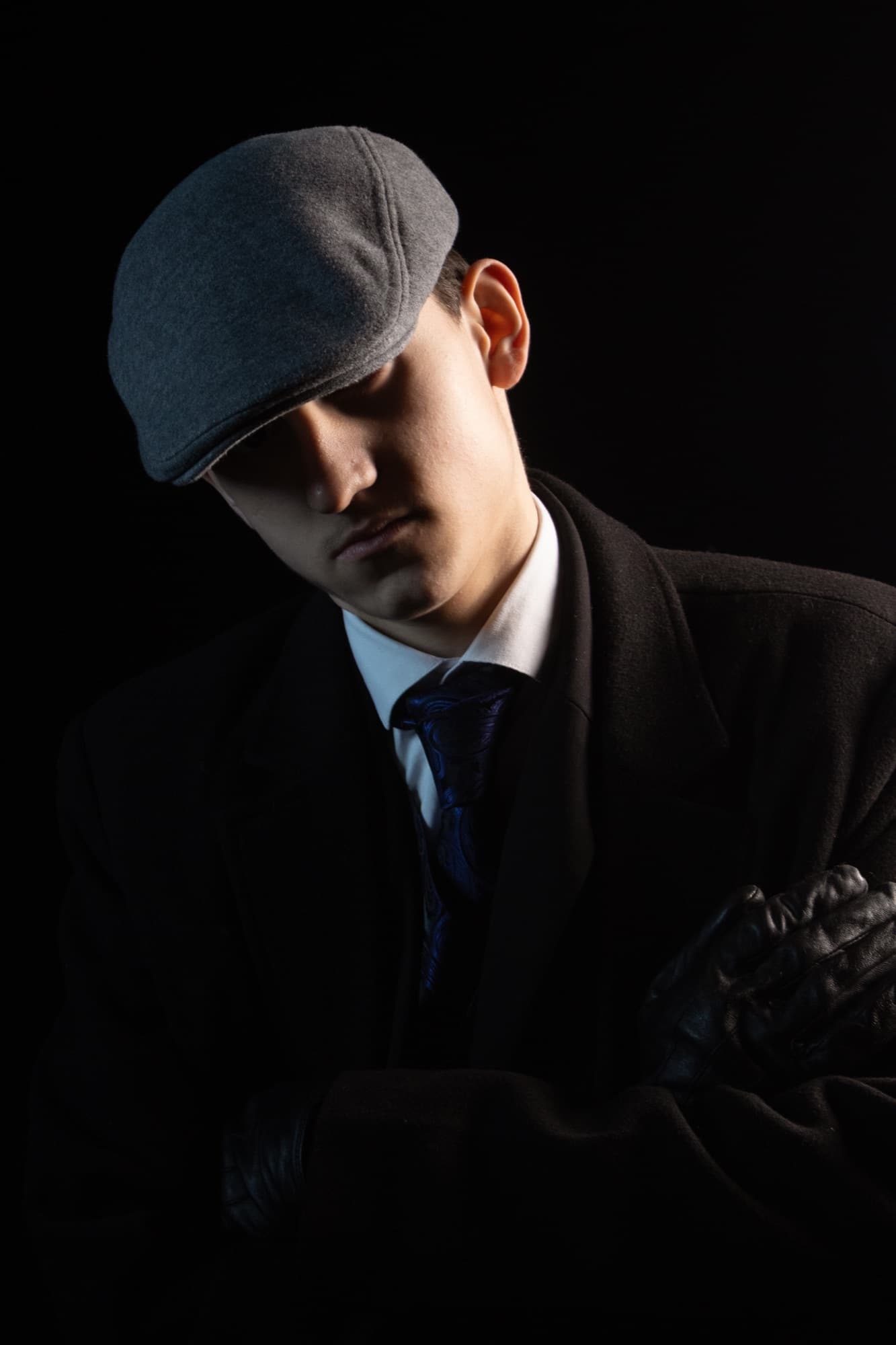 Portrait en clair-obscur, casquette et costume sombre